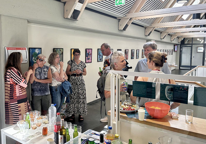 Bezoekers bekijken de kunstexpositie op de derde verdieping van de Universiteitsbibliotheek